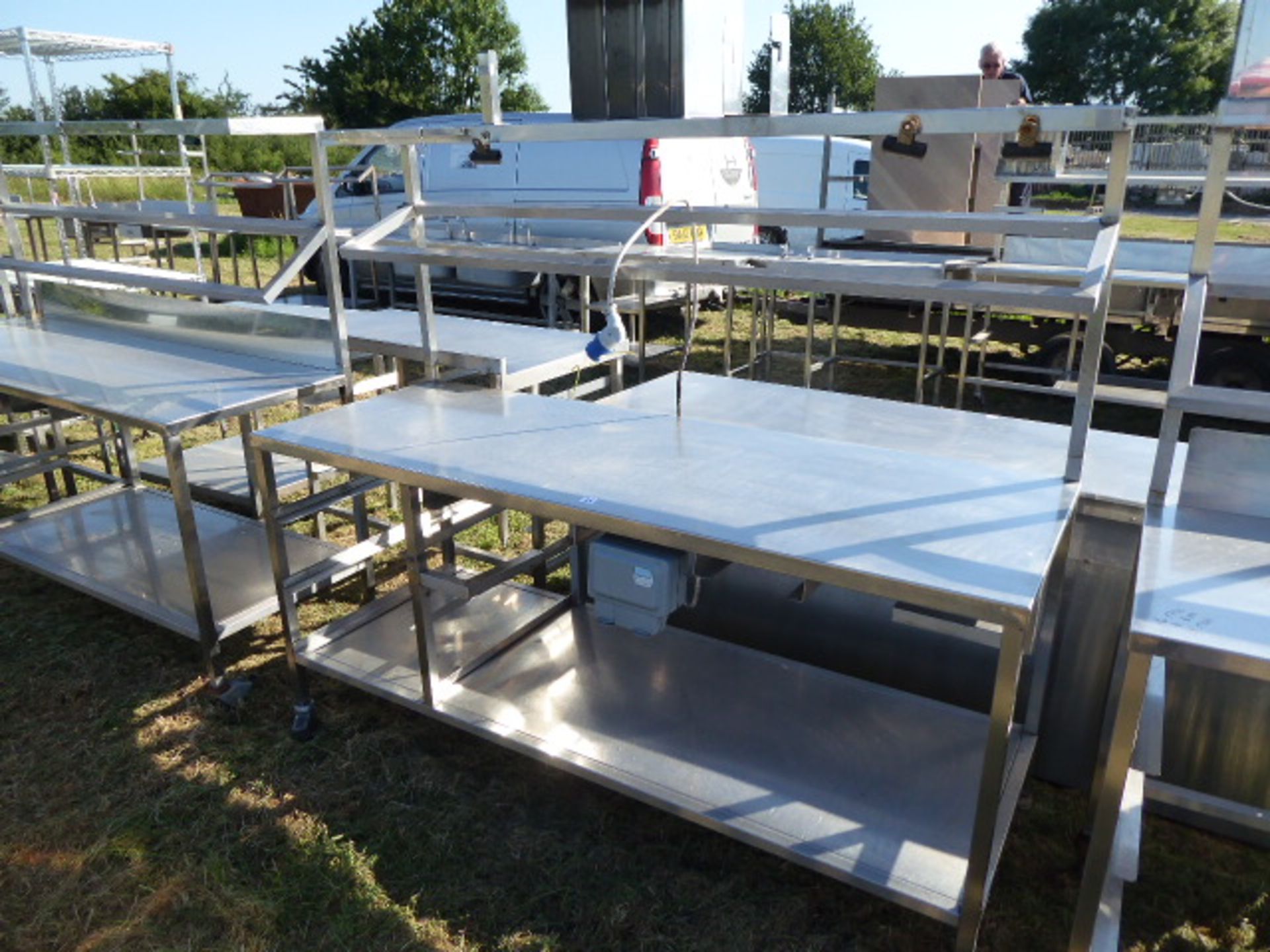 Stainless steel mobile food preparation station with 1 shelf over, shelf under space for trays and a