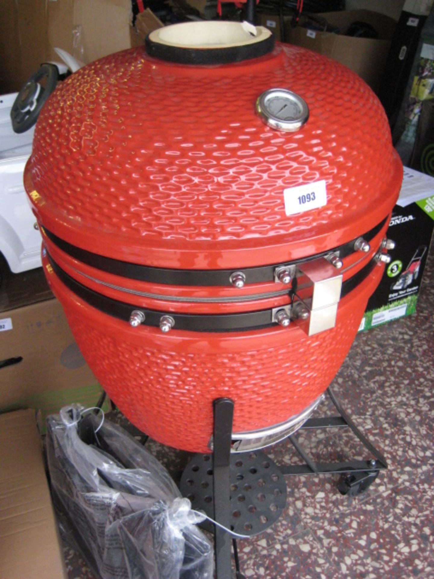 Louisiana ceramic charcoal grill in red with accessories inside