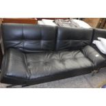 Black leatherette upholstered futon on metal frame