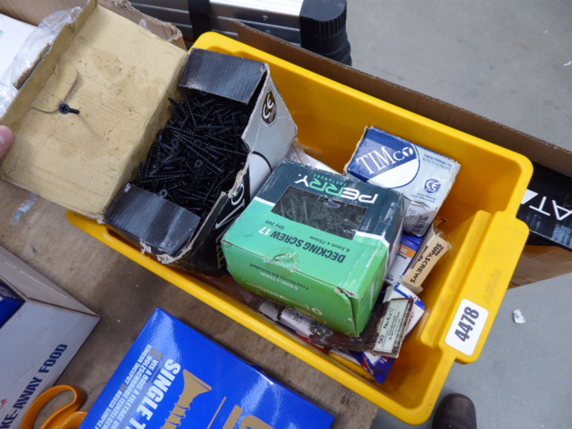 cardboard box and a plastic box containing assorted screws