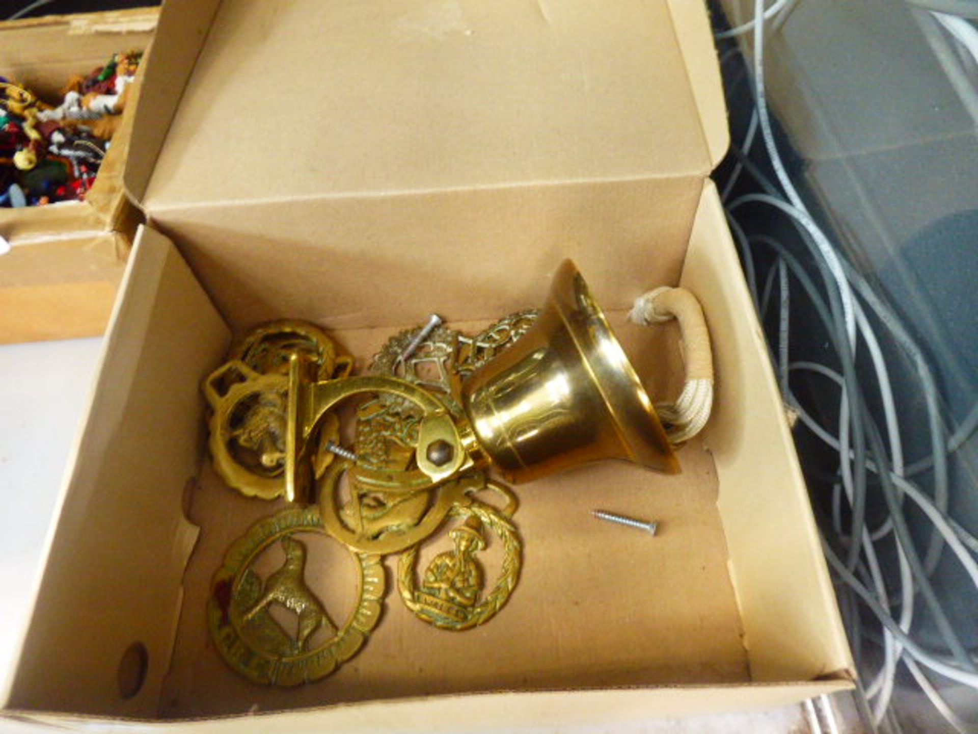 A box of horse brasses and a wall mounted bell