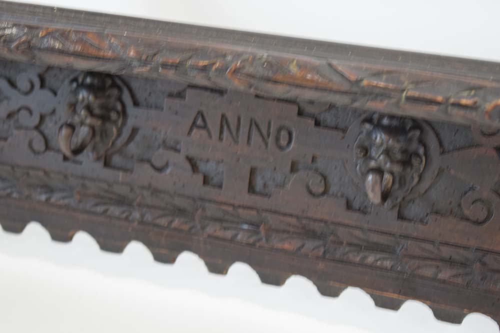 A carved oak hall shelf with figural flanks and four mask head hooks, - Image 3 of 4