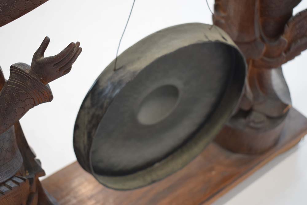 A Tibetan metal gong suspended on a pair of wooden standing figures CONDITION REPORT: - Image 5 of 8