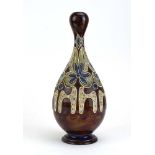 A Doulton Lambeth vase of slender ovoid form relief decorated with stylised flowerheads on a