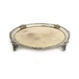 An early 20th century silver gilt salver of circular form with pierced border on four conforming