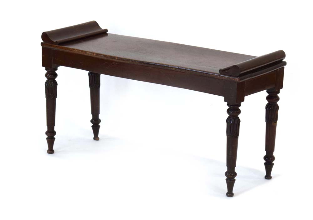 A late 19th century mahogany window seat with scrolled ends and turned legs with acanthus-leaf caps