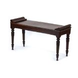 A late 19th century mahogany window seat with scrolled ends and turned legs with acanthus-leaf caps