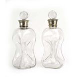 A pair of silver collared decanters of waisted form, maker CA GA, London 1903, h.