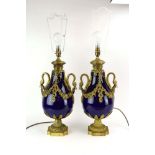 A pair of table lamps with royal blue bodies and mounted with gilt metal swags and swan neck