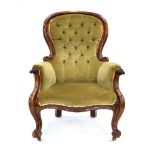 A 19th century mahogany and button upholstered armchair with scrolled arms and matching feet on