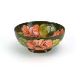 A small Moorcroft bowl decorated with peach hibiscus on a green ground, Queen Mary label to base, d.