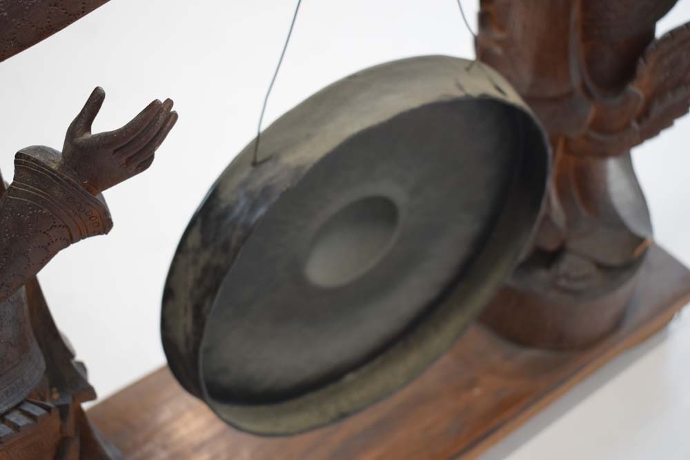 A Tibetan metal gong suspended on a pair of wooden standing figures CONDITION REPORT: - Image 6 of 8