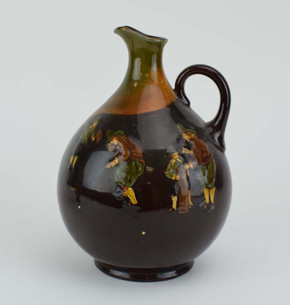 A Royal Doulton jug of ovoid form decorated with a golfer in a treacle glaze, h.