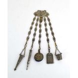 A silver plated chatelaine of typical form suspending a notebook,