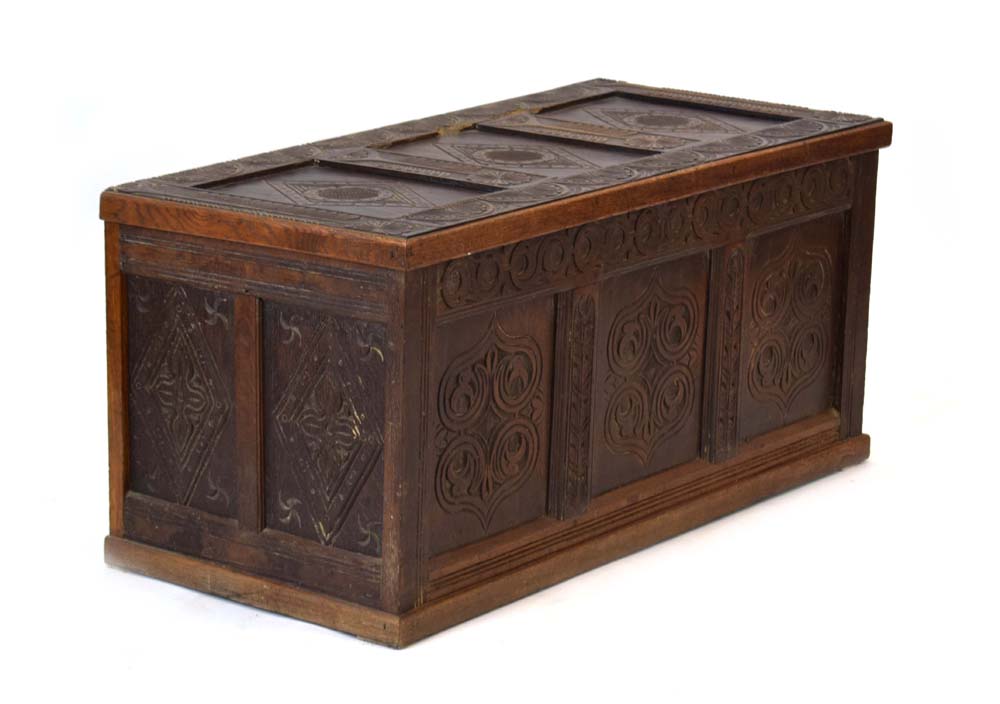 A 20th century oak and panelled coffer decorated with carved foliate carvings throughout, l.