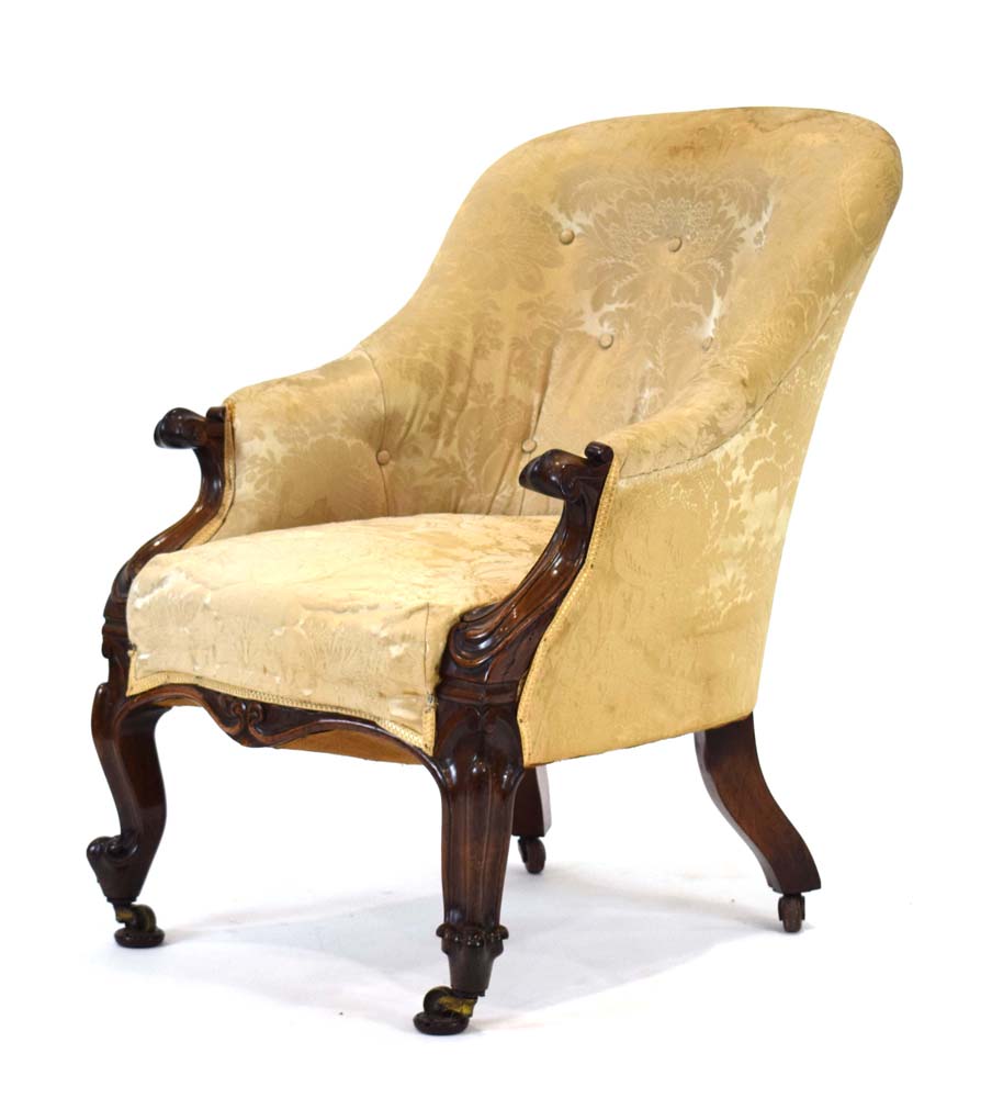 An early Victorian rosewood and button upholstered fireside armchair with scrolled arms and feet,