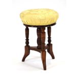 A Victorian oak and upholstered stool with four columns,
