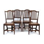 A set of four 18th century Provincial oak chairs with arched and slat backs over solid seats