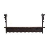 A carved oak hall shelf with figural flanks and four mask head hooks,