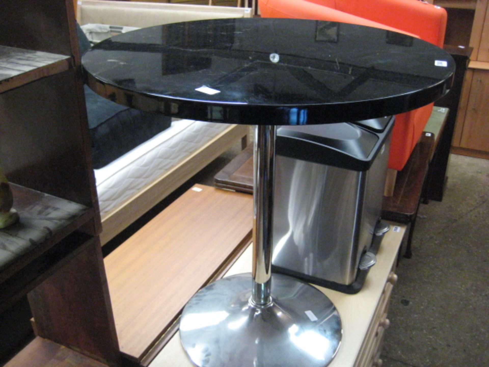 Black table on single pedestal chrome base