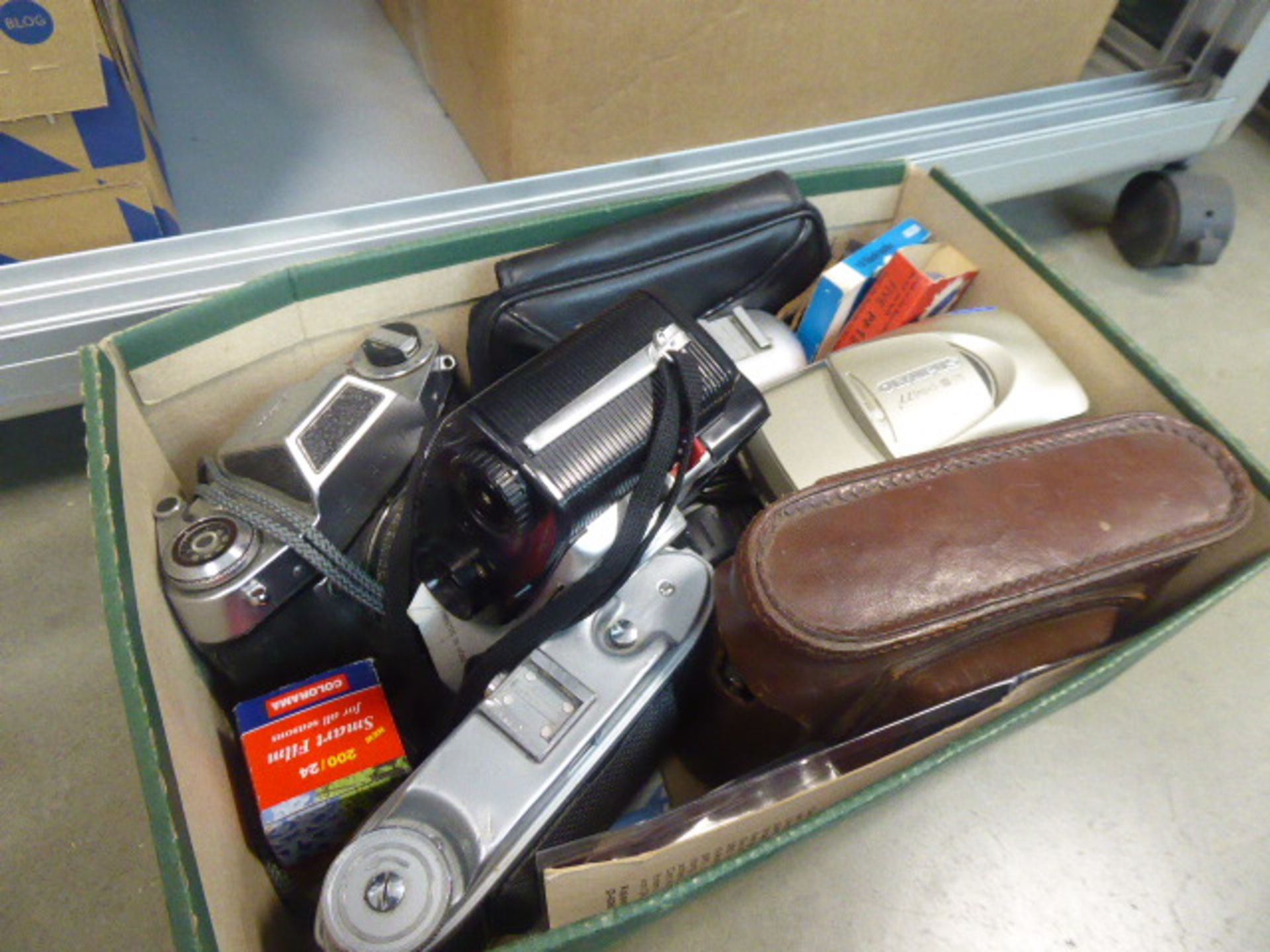 Box containing loose vintage film cameras and accessories