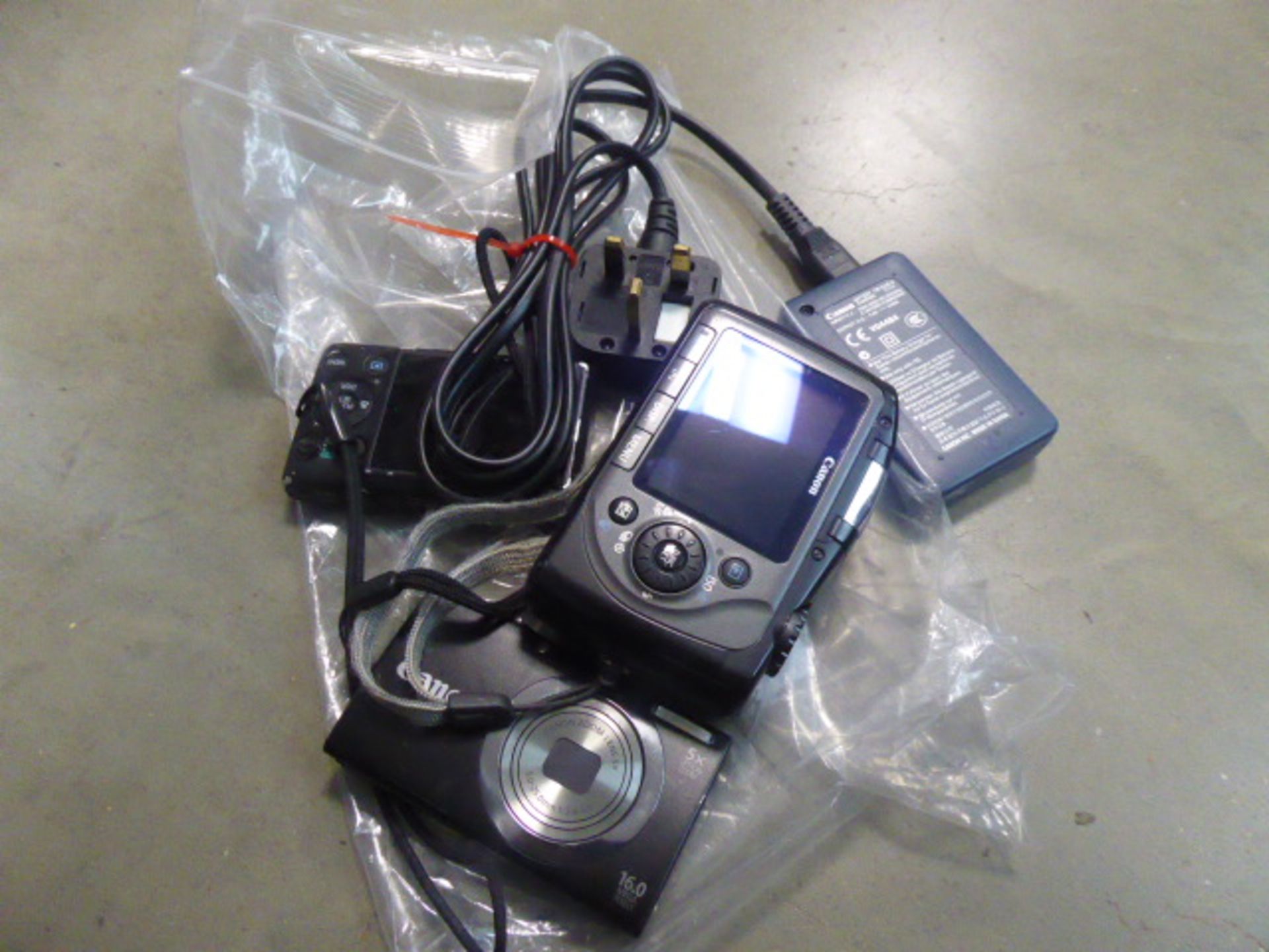 Canon PC 1256 digital camera and a Canon PC 1732 digital camera with loose accessories
