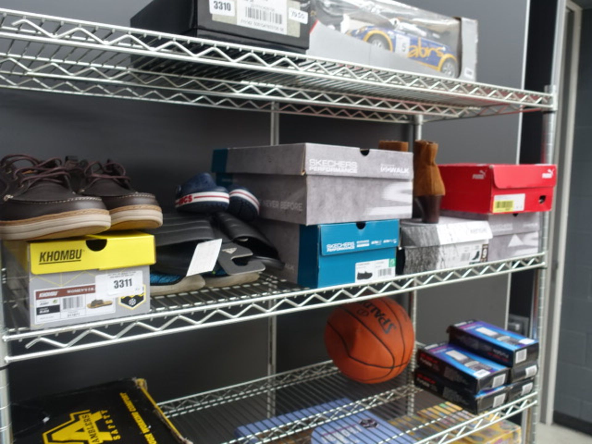 Shelf containing mixed paired shoes including Kumba, memory foam, Skechers, Puma, Adidas sandals etc