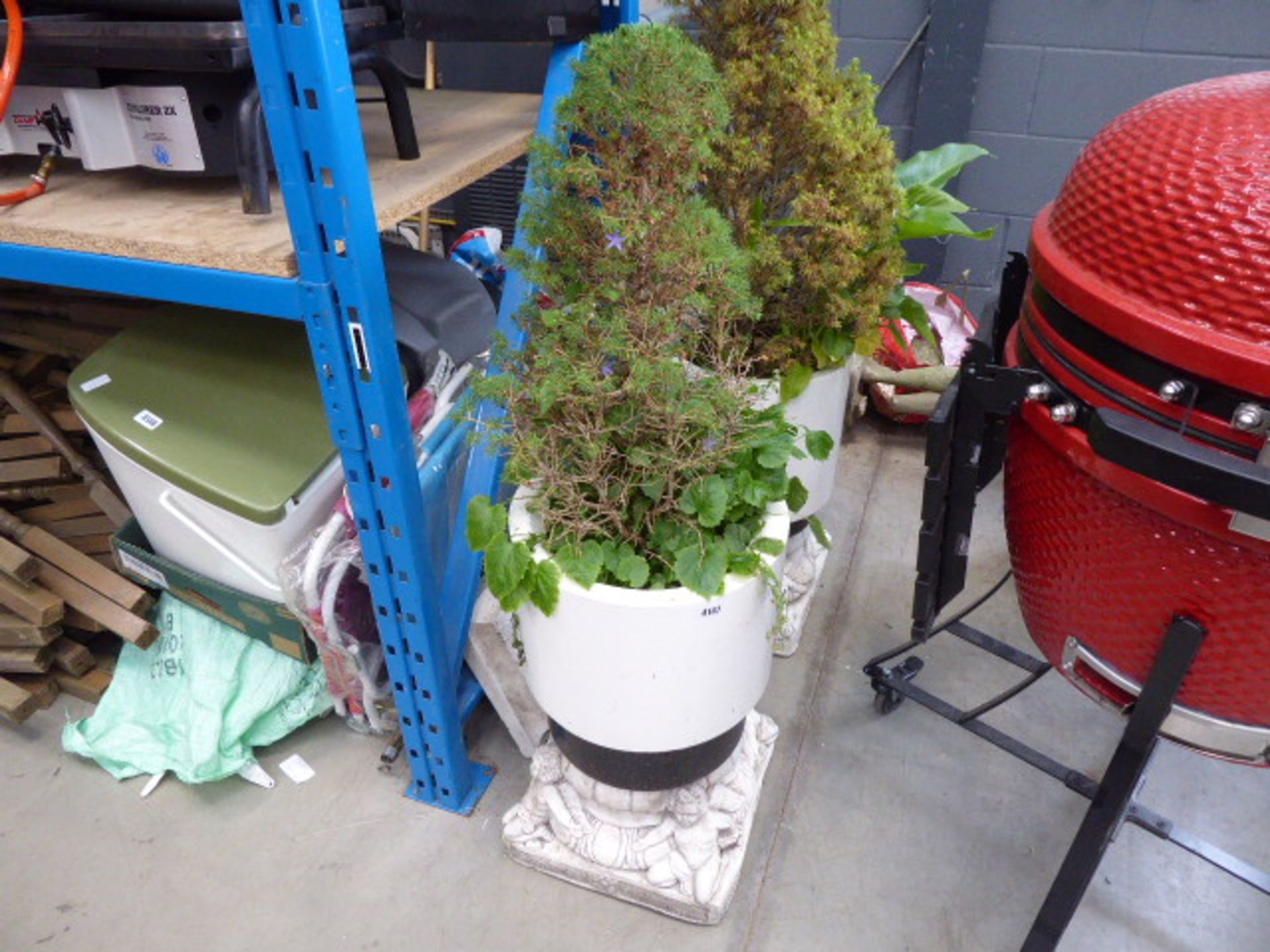 2 white round plastic pots of concrete plinths with cherubs