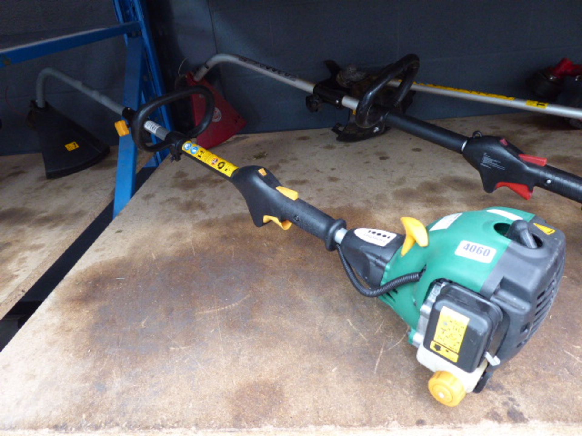 Green petrol powered strimmer