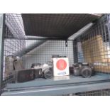 Cage containing a quantity of cameras and lenses