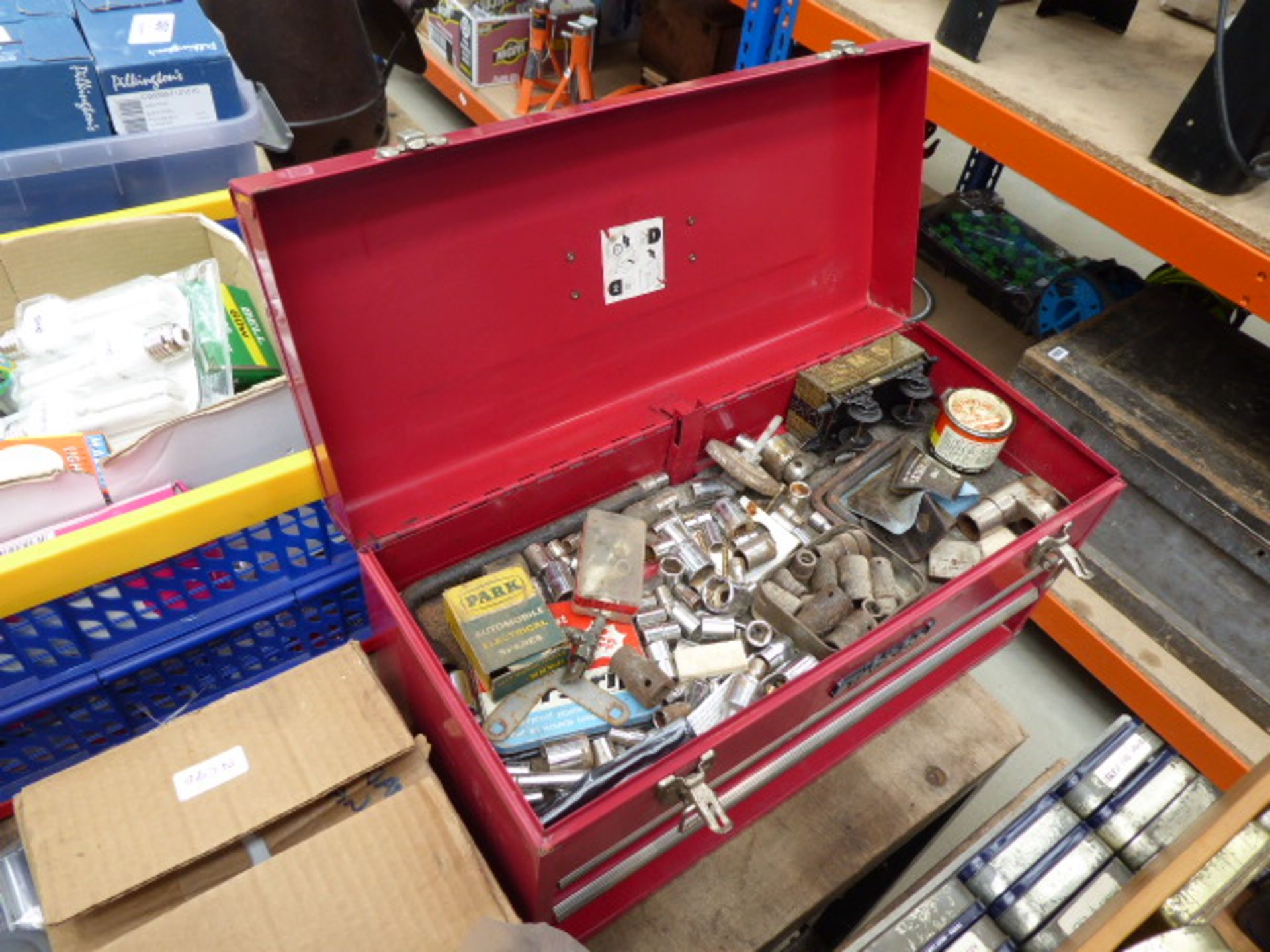 Red metal toolbox with small quantity of assorted tools