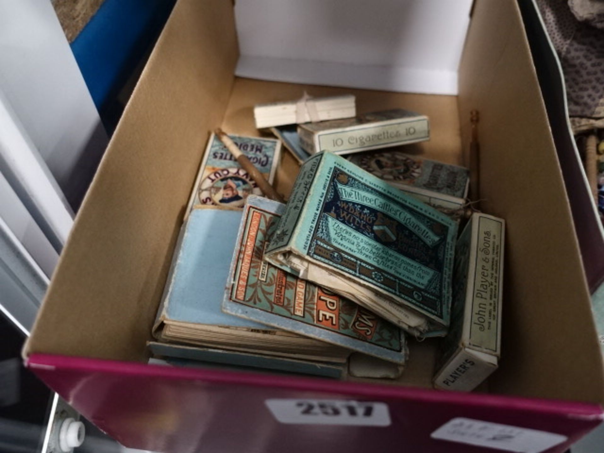 Cardboard box containing various loose bobbins and Wills Player cigarette cards