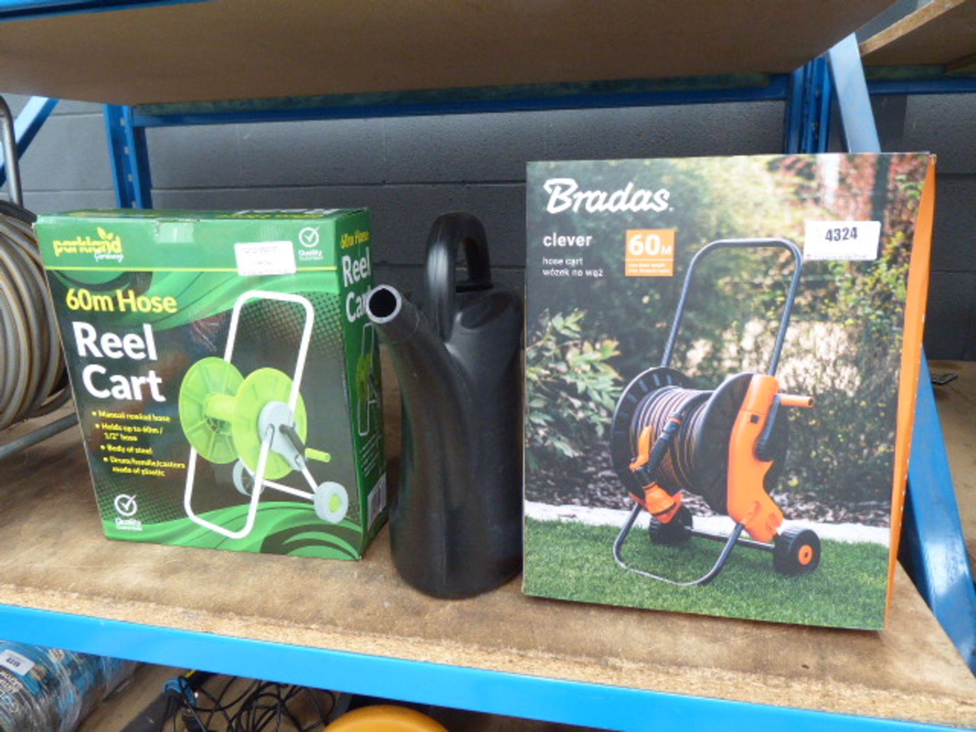 2 Boxed hose reels and a watering can