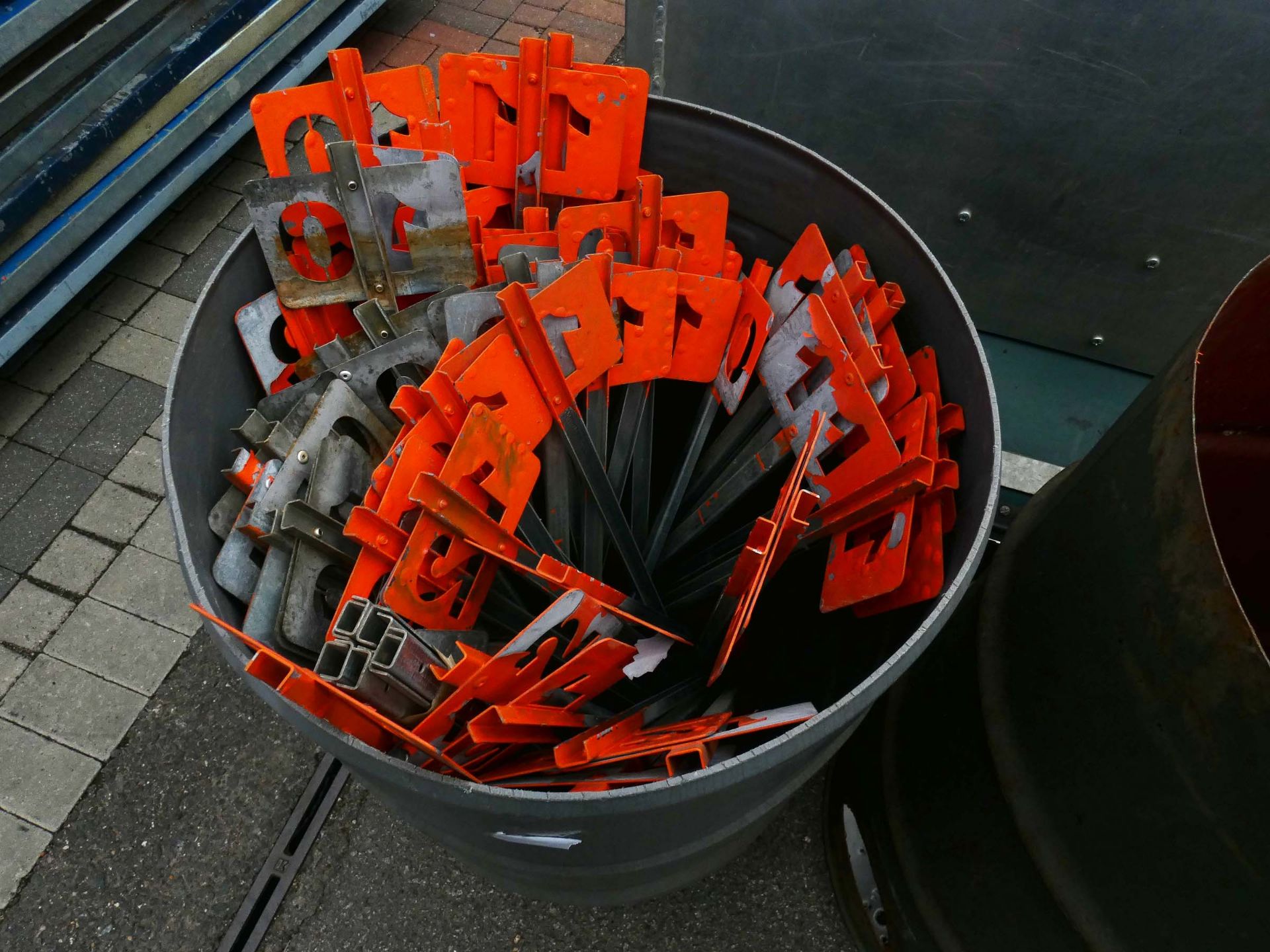 Barrel containing a quantity of mixed galvanized gun peg numbers (1-10, with duplicates, incomplete)