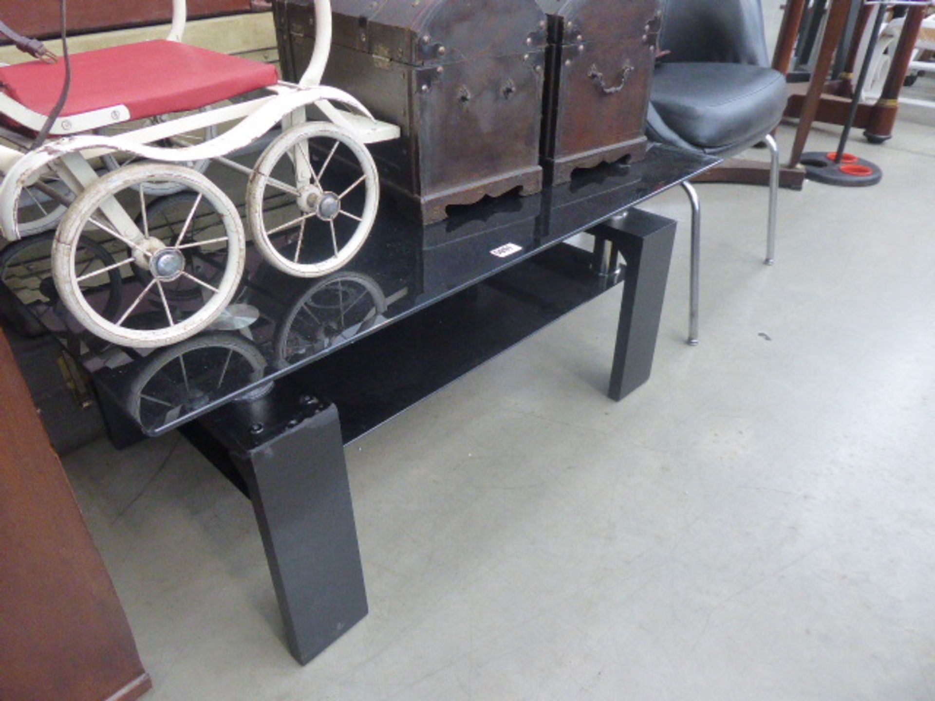 Black glass topped coffee table with glass shelf under