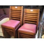 Set of 11 wooden framed stackable dining chairs with maroon coloured seat pads