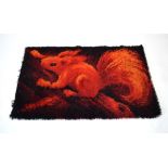 A 1960/70's woolen rug, the dark ground with a red squirrel,
