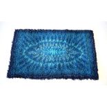 A 1970's woolen rug with a blue ground, 61 x 97 cm CONDITION REPORT: Colours good.