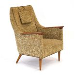 A 1960's Danish highback armchair, the oatmeal upholstery with exposed teak arms and tapering legs,