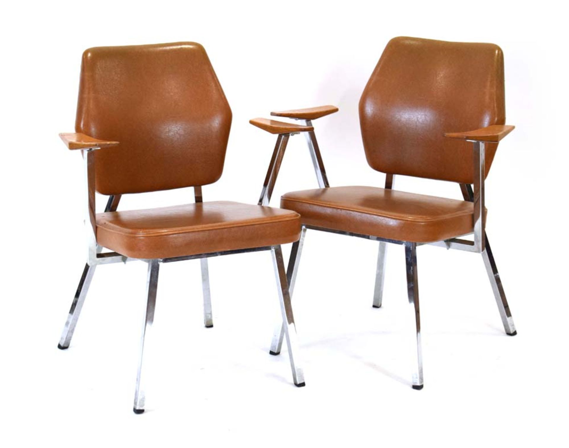 A pair of Swedish armchairs with tan vinyl upholstery, teak angular arms and chromed frames,