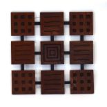 A teak and routed nine-panel wall hanging, w.