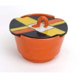 An Art Deco lidded pot by Goldscheider with an orange body and an orange, yellow and black lid, h.