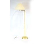 A 1970's-style brass finished standard lamp with an adjustable swivel shade CONDITION