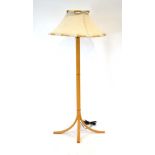 A 1960/70's beech standard lamp with splayed legs and a fabric shade CONDITION REPORT:
