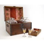 An oak and metal bound case containing a travelling set of etched glass and gilt decanters and