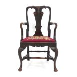 A 19th century mahogany open armchair in the 18th century manner, with a shell decorated splat,