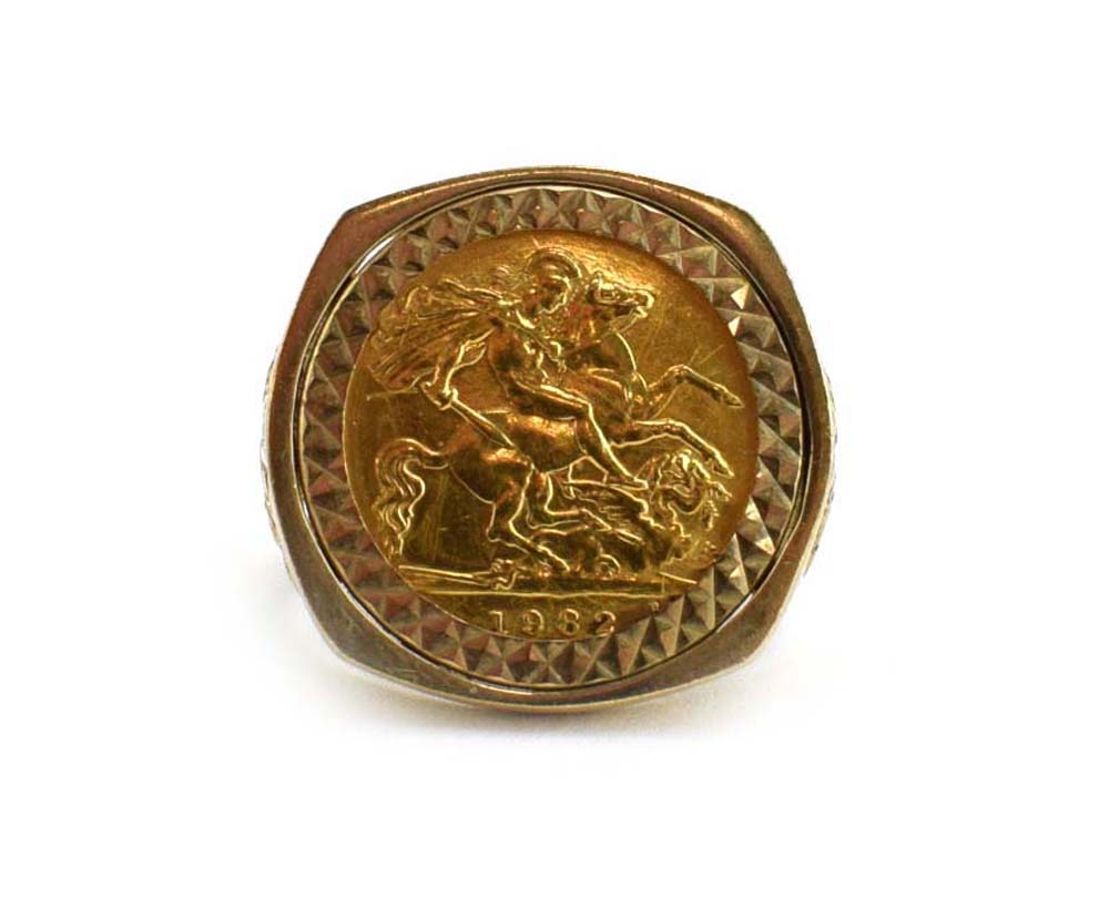 A 9ct yellow gold ring set half sovereign dated 1982 in a loose pierced George and the dragon mount,