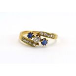 A late Victorian 18ct yellow gold crossover ring set old cut diamond and two sapphires,