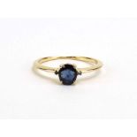 A modern 9ct yellow gold ring set oval sapphire in a four claw setting and two smaller sapphires,