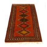 A mid-to-late 20th century rug decorated with bright colours and six medallions,